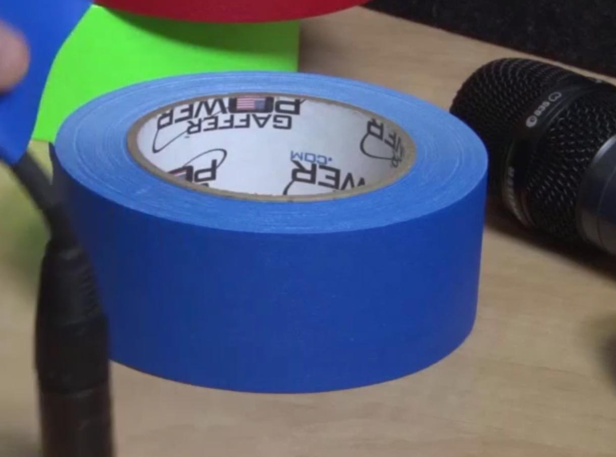 CU of Electric blue gaffer tape covering electrical cord to keep cables organized
