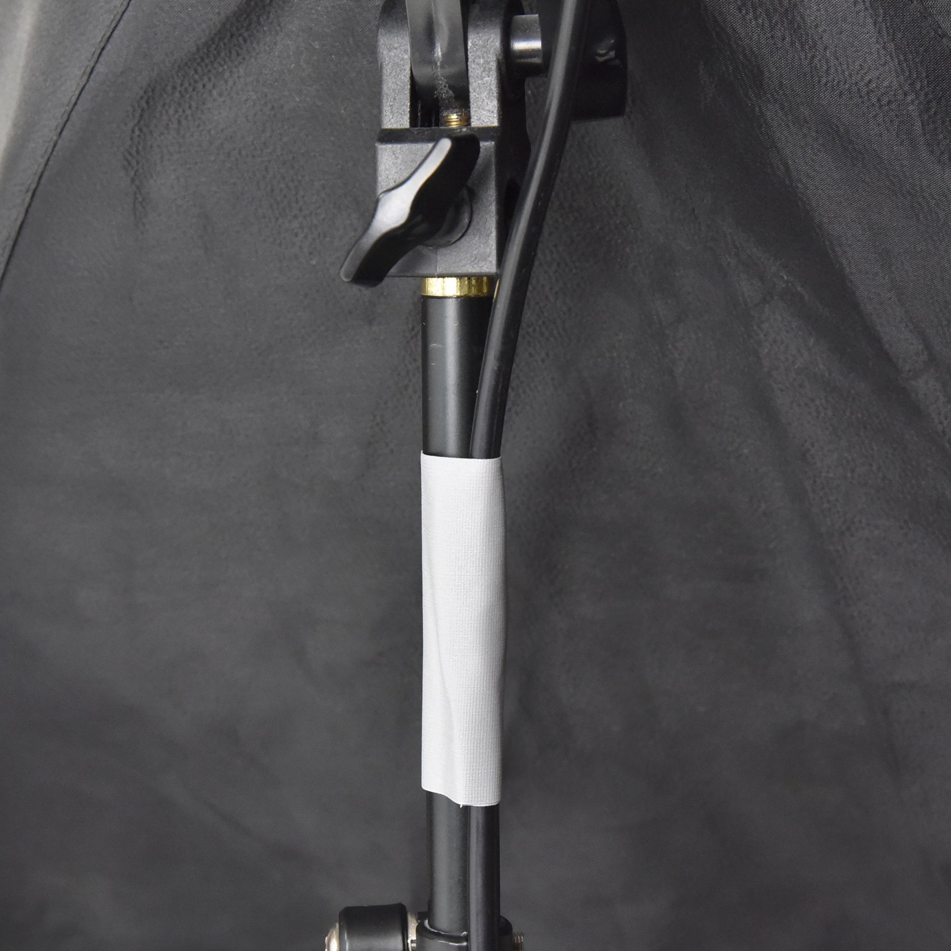 Grey gaffer tape attaching electrical cable to light stand for clean cable routing on film or photography set