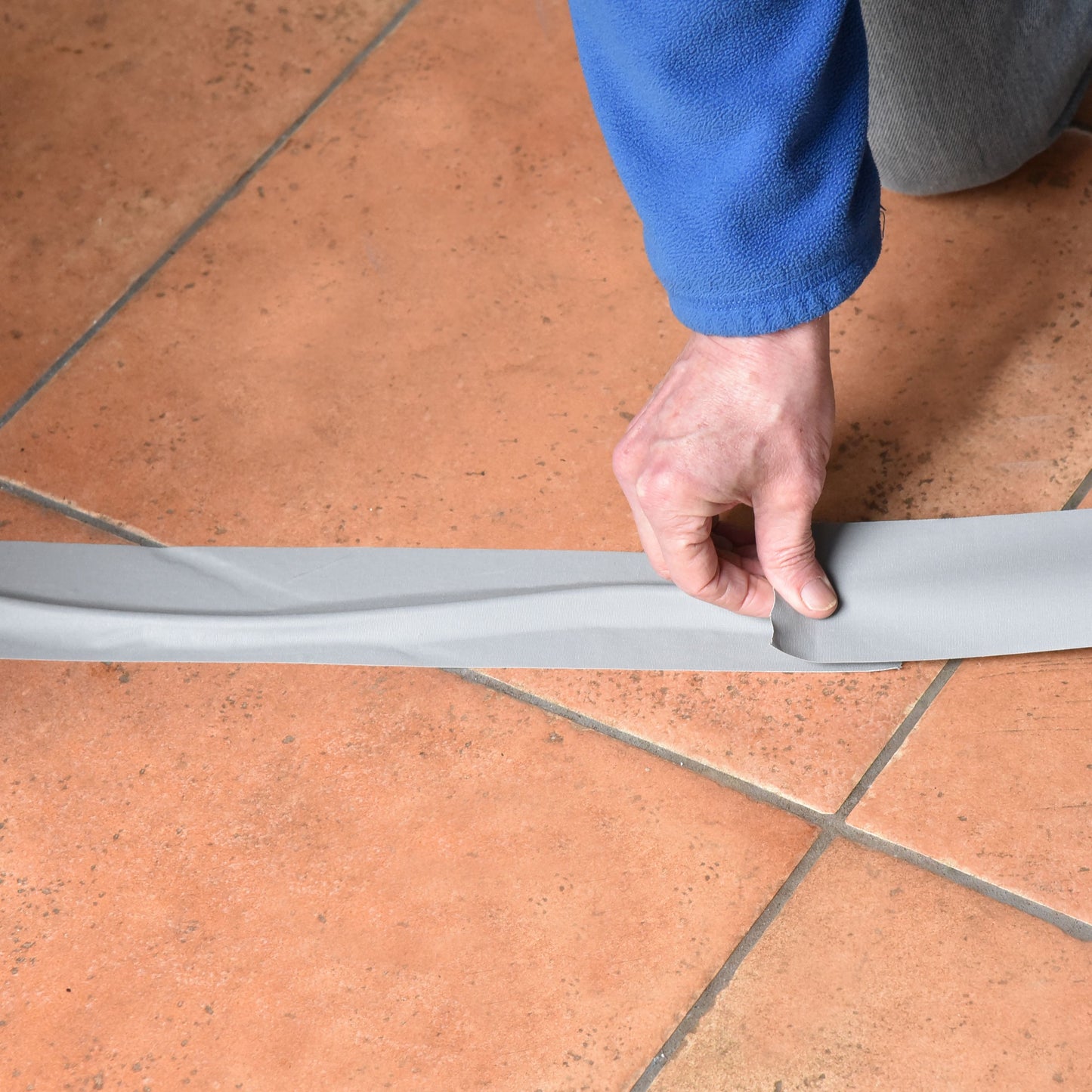 Grey 3 inch gaffer tape securing electrical cables to floor for safe cable management during stage or event setup